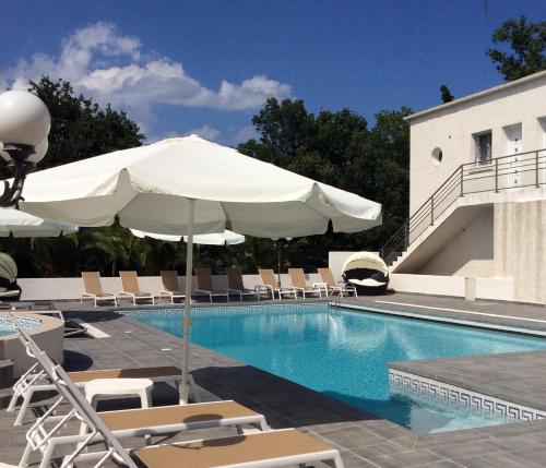 莫里亚尼海滩旅游收获假日公园酒店的一座带椅子和遮阳伞的游泳池位于大楼旁