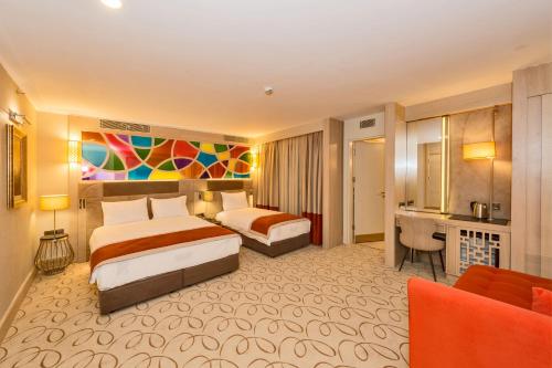 伊斯坦布尔MARE PARK Hotel & SPA的酒店客房配有两张床和一张书桌