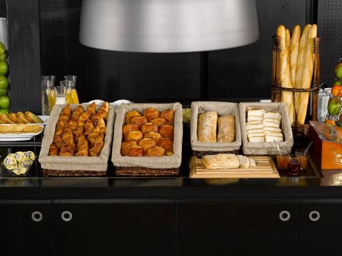 保拉扎克Ampaline HOTEL - Perigueux Boulazac的自助餐,包括几个糕点和面包盘