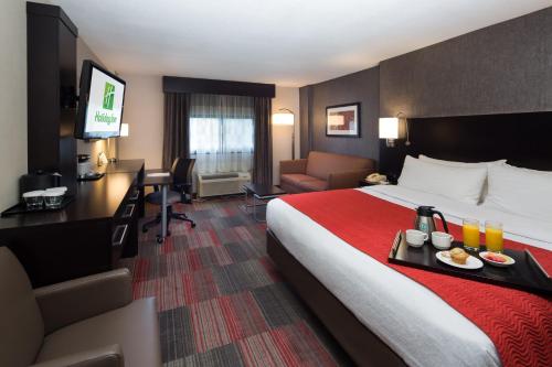 密尔沃基密尔沃基滨河假日酒店的酒店的客房 - 带一张床和一张带食品托盘的书桌