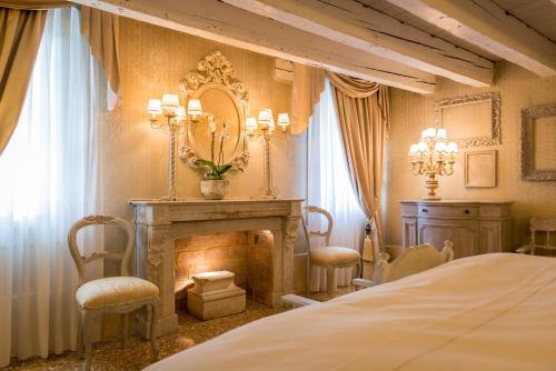 威尼斯卡玛丽亚阿黛尔旅馆的一间卧室设有壁炉和一张床