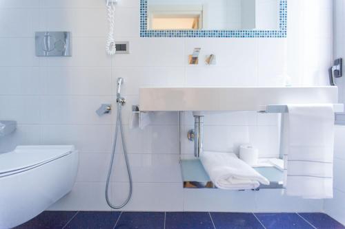 米兰皮亚琴察酒店的白色的浴室设有水槽和卫生间。