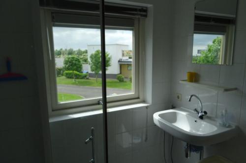 考德姆vakantiehuisgalamadammen met ligplaats boot的一间带水槽和窗户的浴室