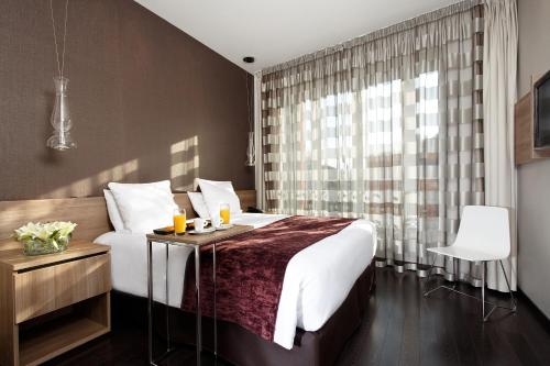 图卢兹斯特兹酒店的一间卧室设有一张大床和一个窗户。