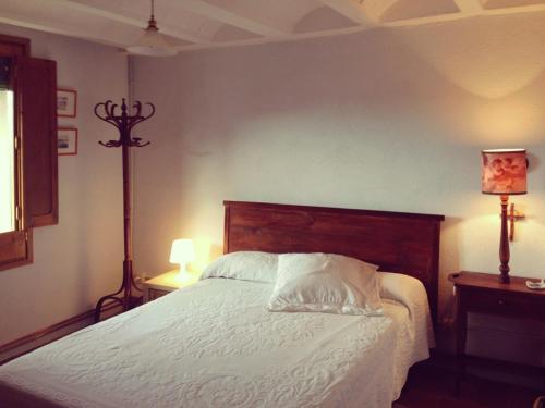 阿尔彭斯Cal Son的一间卧室配有一张带白色床单和两盏灯的床。