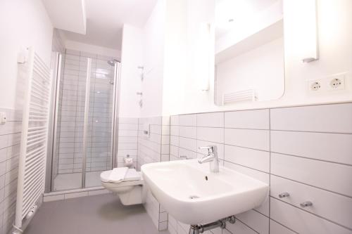 瓦尔内明德Hafenapartments Warnemünde的白色的浴室设有水槽和卫生间。