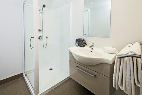 奥克兰奎斯特奥尔巴尼服务式公寓的带淋浴和盥洗盆的白色浴室