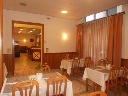 沃洛斯阿德米托斯酒店的一间带桌椅的用餐室和窗户。
