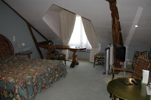 瓦拉日丁Chateau d'Hassonville的一间卧室配有一张床、一台电视和一张桌子