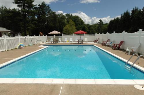 Center Conway萨库河汽车小屋&套房酒店的一个带白色围栏的庭院内的游泳池
