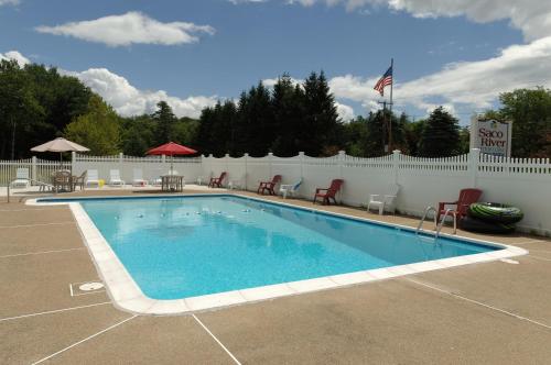 Center Conway萨库河汽车小屋&套房酒店的一个带椅子和白色围栏的游泳池