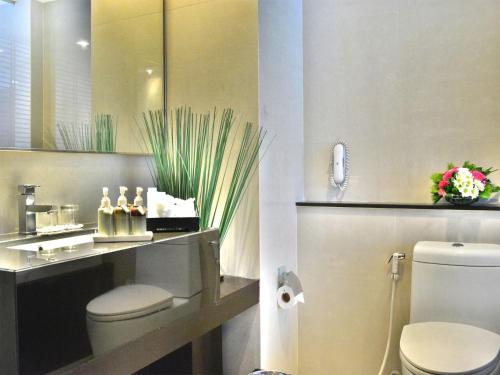曼谷爱湾精品酒店的一间带卫生间、水槽和镜子的浴室