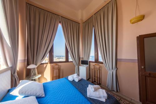 加利波利瓦莱博纳宫住宿加早餐旅馆的一间卧室配有蓝色的床和毛巾