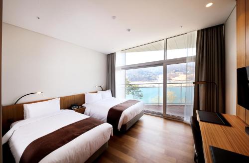 加平麦达斯酒店及度假村的配有大窗户的酒店客房内的两张床