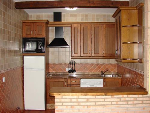 塞古拉 - 德拉谢拉塞古拉山脉公寓的厨房配有木制橱柜和白色冰箱。