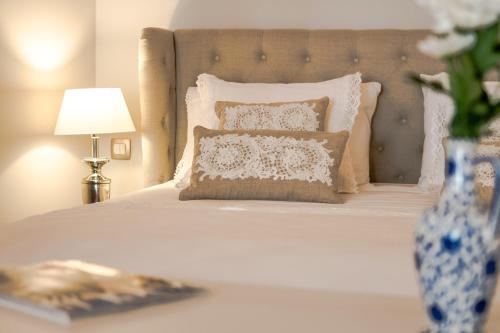 赫瓦尔Heritage suites Zanini的卧室配有白色的床和花瓶