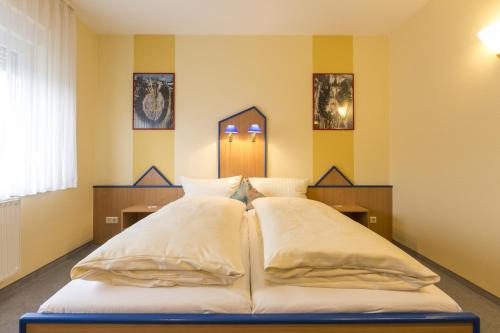 加尔布森格罗特尔商务酒店的黄色墙壁客房的两张床