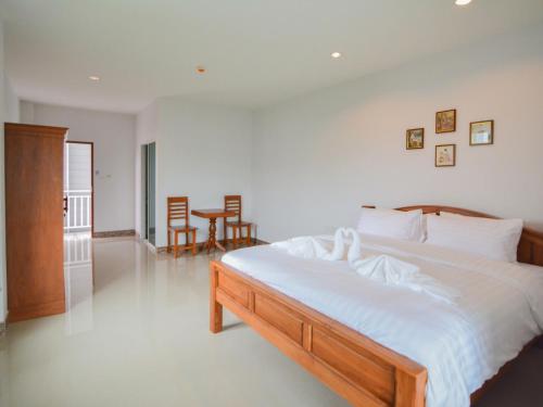 华欣班约克哈尼酒店的一间卧室配有一张带白色床单的大床