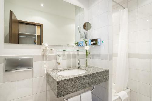科隆Hotel Mariella的白色的浴室设有水槽和镜子