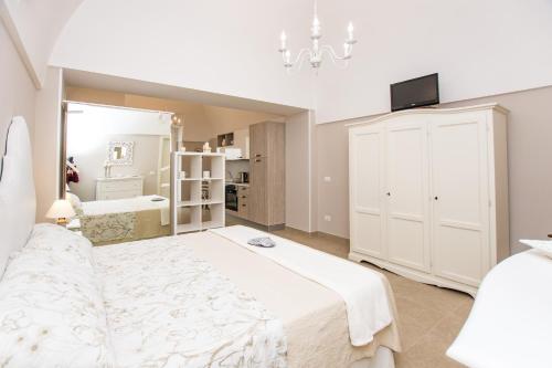 莫诺波利Casa Velia的白色卧室设有一张大床和镜子