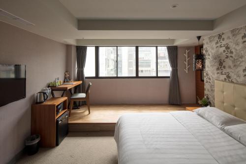台北悠趣旅店的一间卧室配有一张床、一张书桌和一个窗户。