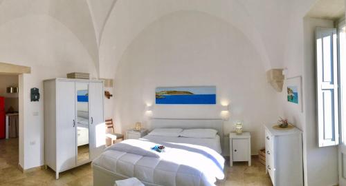 波贾尔多La Loggia Salentina的白色卧室配有床和镜子