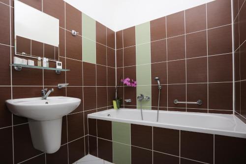 波杰布拉迪Hotel Zámeček的浴室配有盥洗盆和浴缸。