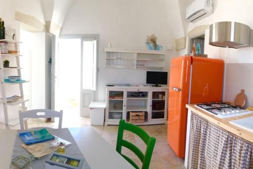 波贾尔多La Loggia Salentina的厨房配有橙色冰箱和桌子