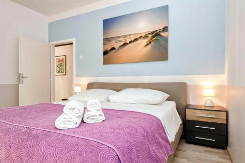 斯普利特Apartment Maja的一间卧室配有一张紫色床和毛巾