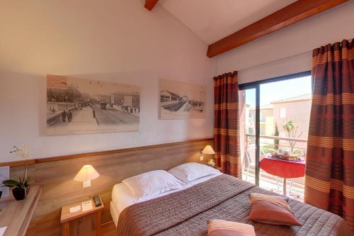 格吕桑Hotel Le Phoebus Garden & Spa的一间卧室设有一张床和一个大窗户