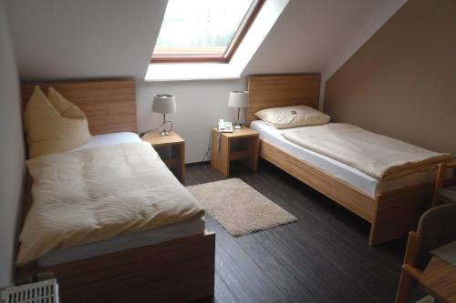 希尔德斯海姆奥斯特伯格餐厅酒店的一间小卧室,配有两张床和窗户