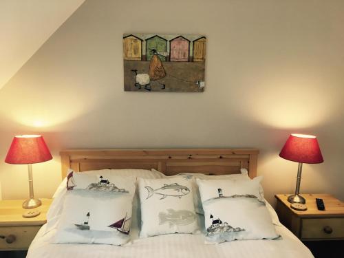 欧弗斯特兰德The White Horse的卧室配有带枕头的床铺和墙上的绘画