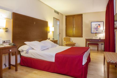 卡塞雷斯唐费尔南多索霍精品酒店的酒店客房设有一张大床和一张书桌。
