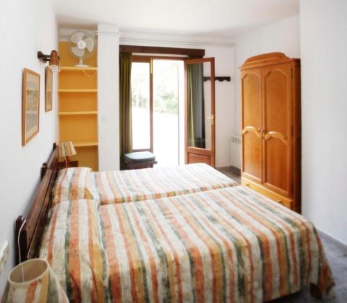 卡拉菲格拉洛伦佐别墅酒店的一间卧室配有带条纹毯子的床