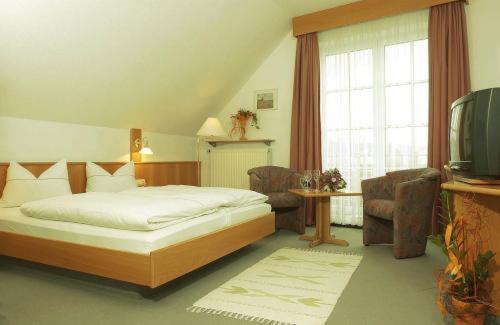 明希贝格罗塞尼尔酒店的一间卧室配有一张床和一台电视。