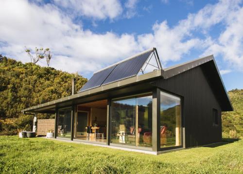 塔卡卡Golden Bay Hideaway的一座带太阳能屋顶的黑色房子