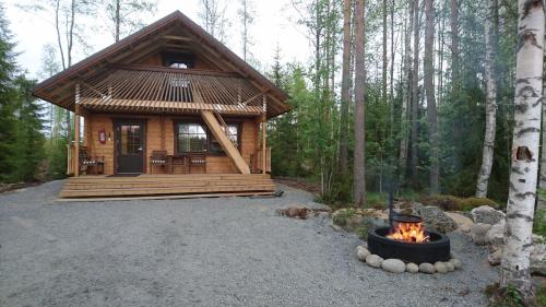 Peräseinäjoki玛提拉玛特凯鲁劳玛奇酒店的木头上的小木屋,带火坑