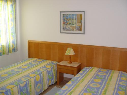 阿玛考德佩拉菲古林豪斯乡间别墅酒店的一间卧室设有两张床和一张桌子上的台灯。