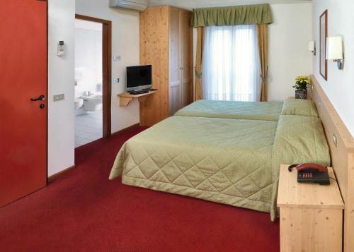 佩尔吉内瓦尔苏加纳罗通达酒店的酒店客房,配有床和电视