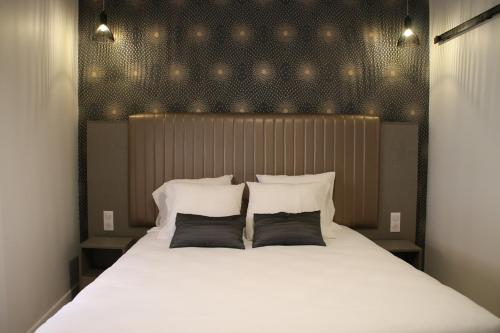 里昂圣文森特酒店的卧室配有一张带两个枕头的大白色床