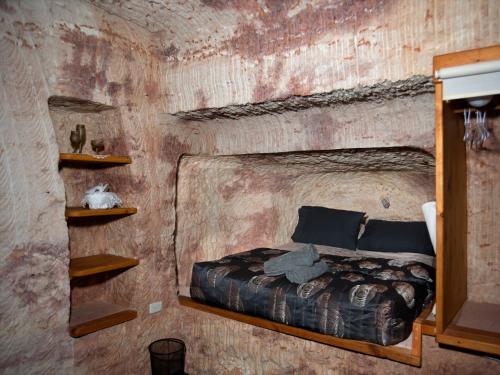 库伯佩迪Ali's Underground Studio的砖墙间内一间卧室,配有一张床