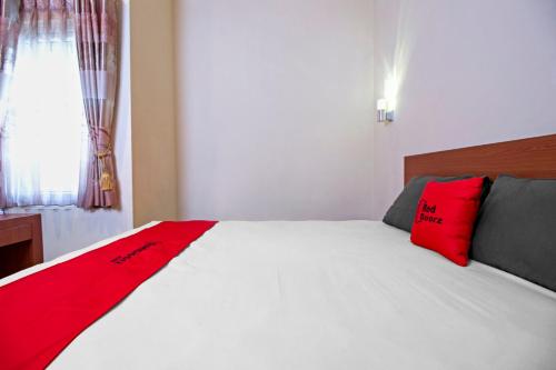 万隆万隆超级商城2号红门旅馆的卧室配有带红色枕头的白色床