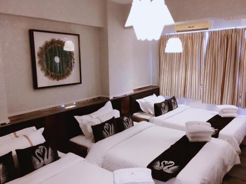 香港季节酒店 - 铜锣湾的酒店客房设有三张床和吊灯。