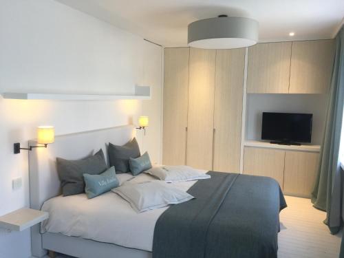 德哈恩Villa Emilia的一间卧室配有带枕头的床和电视。