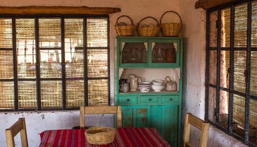 乌尼翁镇Chakana Hospedaje Rural的厨房配有绿色橱柜和桌椅