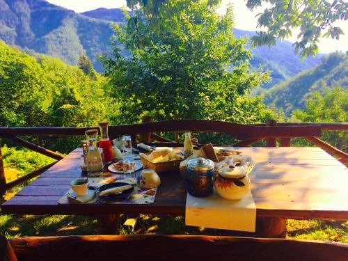 Molino del PalloneB&B La Presa的一张木桌,上面有食物,后面有山