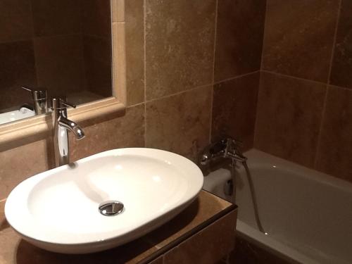 里耶两只狮子酒店的浴室配有白色水槽和浴缸。