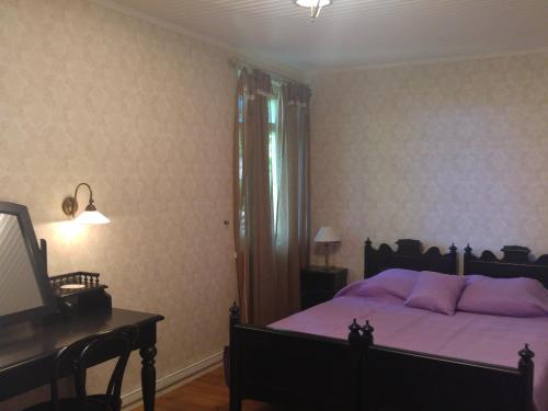 凯尔德拉妈妈咪呀旅馆的一间卧室配有一张带紫色床单的床和一架钢琴