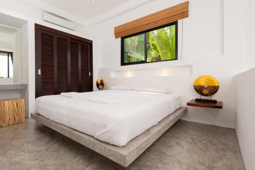 涛岛涛岛种植园公寓的白色卧室设有一张大床和窗户