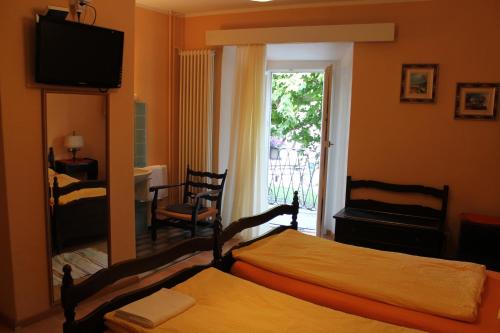 卡斯拉诺欧斯特里亚巴特罗旅馆的一间卧室设有两张床、一台电视和一扇窗户。